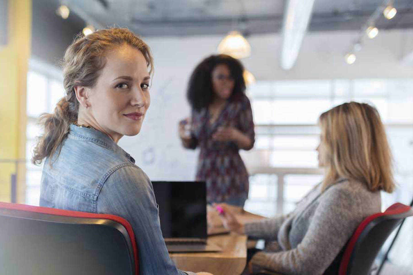 Junge Frau sitzt in einem Meeting