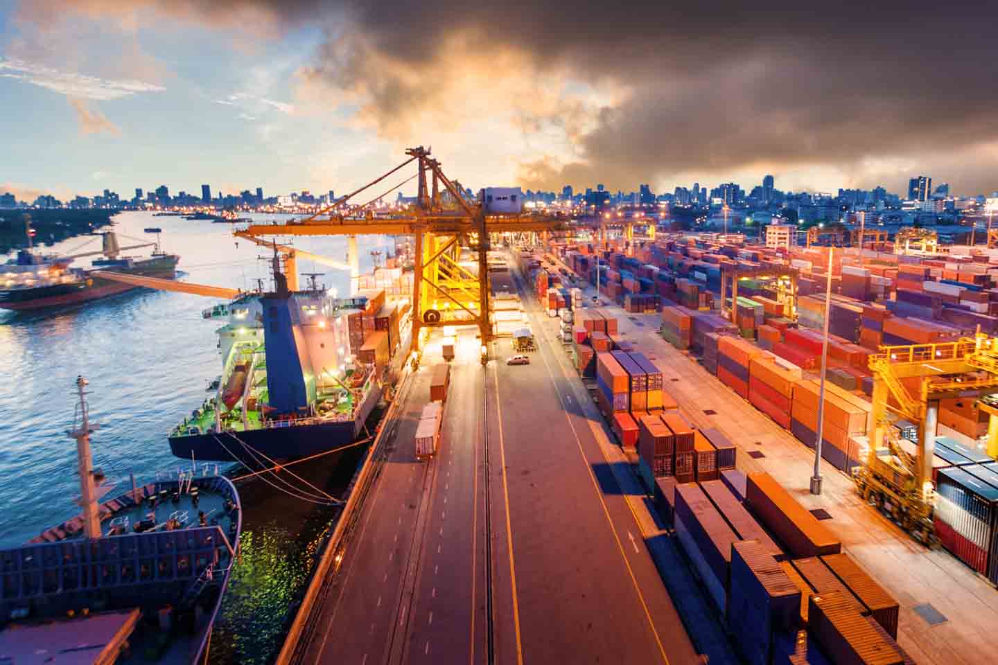 Blick über einen großen Hafen mit Schiffen und vielen Containern.