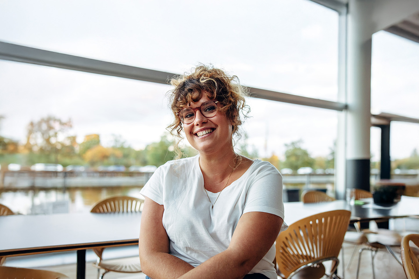 Frau mit Brille strahlt in die Kamera