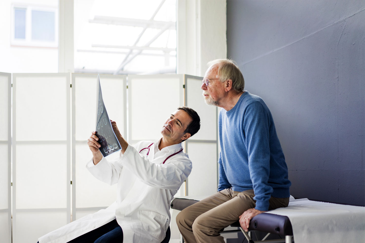 Arzt zeigt dem Patienten Röntgenbilder