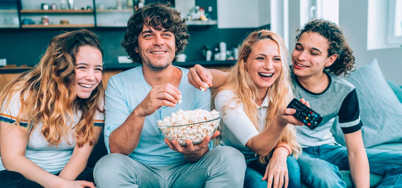 Junge Leute auf dem Sofa, die TV gucken