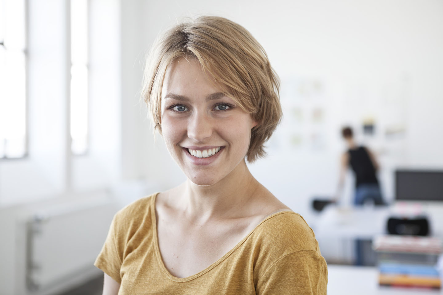 Portraitfoto einer jungen Frau, die in die Kamera lächelt.