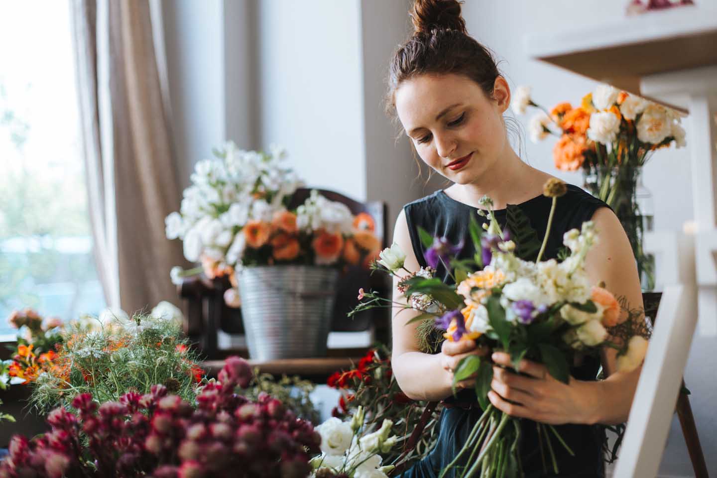 Junge Frau bindet einen Blumenstrauß im Blumenladen.