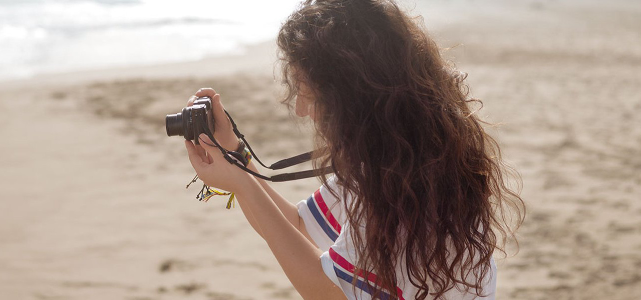 Eine Frau macht Bilder am Strand.