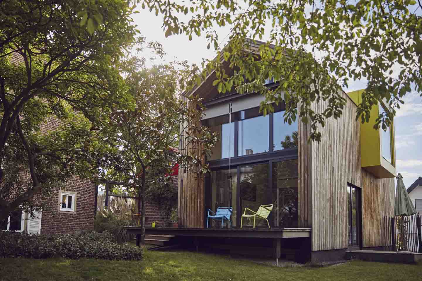 Ein Holzhaus mit zwei Kunststoffstühlen auf der Terrasse.