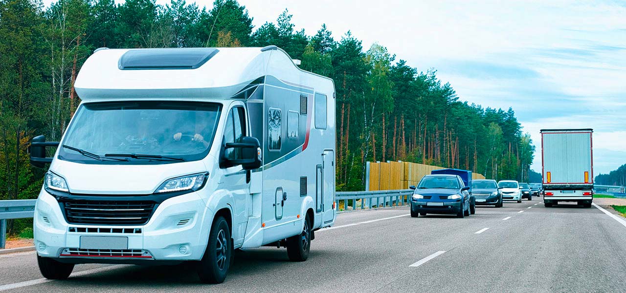 Ein Wohnmobil fährt mit anderen Kraftfahrzeugen auf einer Straße.