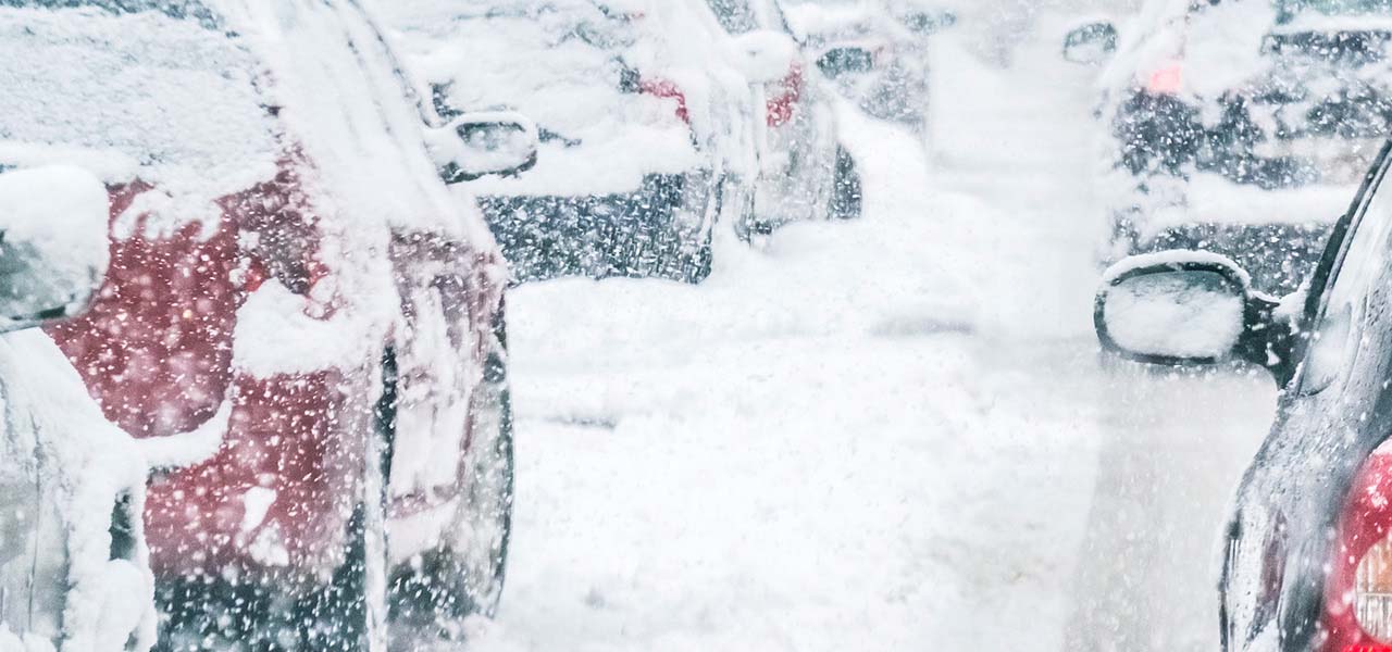 Autos stehen im Stau, bei dichtem Schneetreiben.