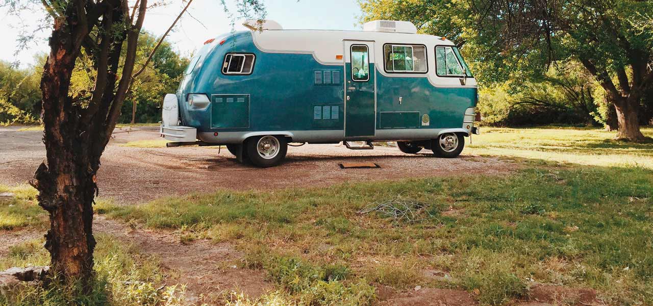 Pastellblauer Campingwagen im Grünen.