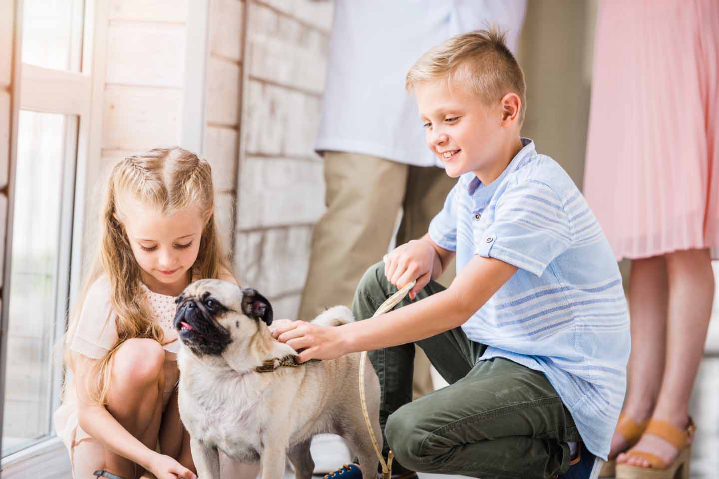 Ein Junge und ein Mädchen mit einem Mops.