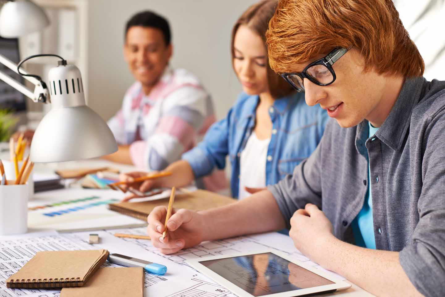 Studenten sitzen gemeinsam an einem Schreibtisch.