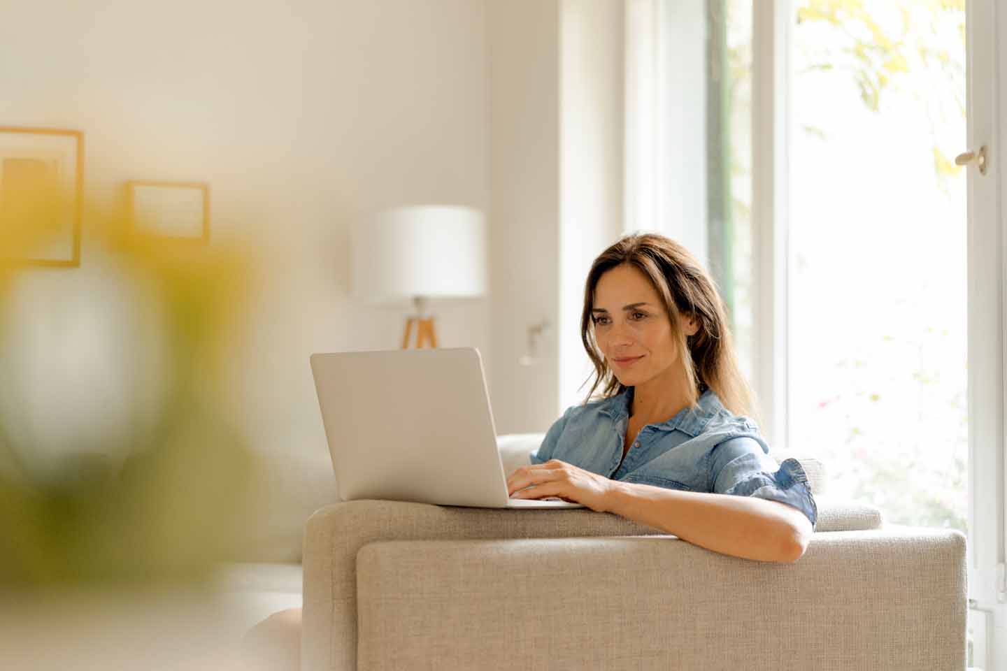 Frau auf dem Sofa mit Laptop