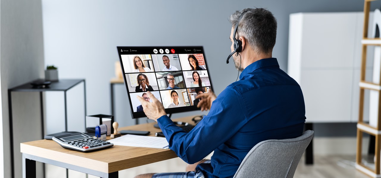Ein Mann hat ein virtuelles Arbeits-Meeting in den eigenen vier Wänden.