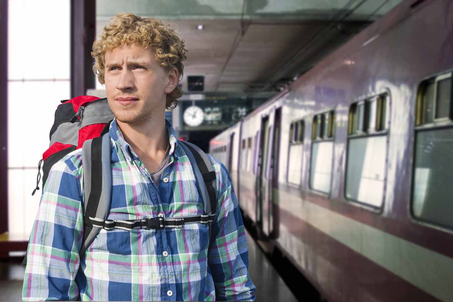 Ein junger Mann steht vor einem Zug.