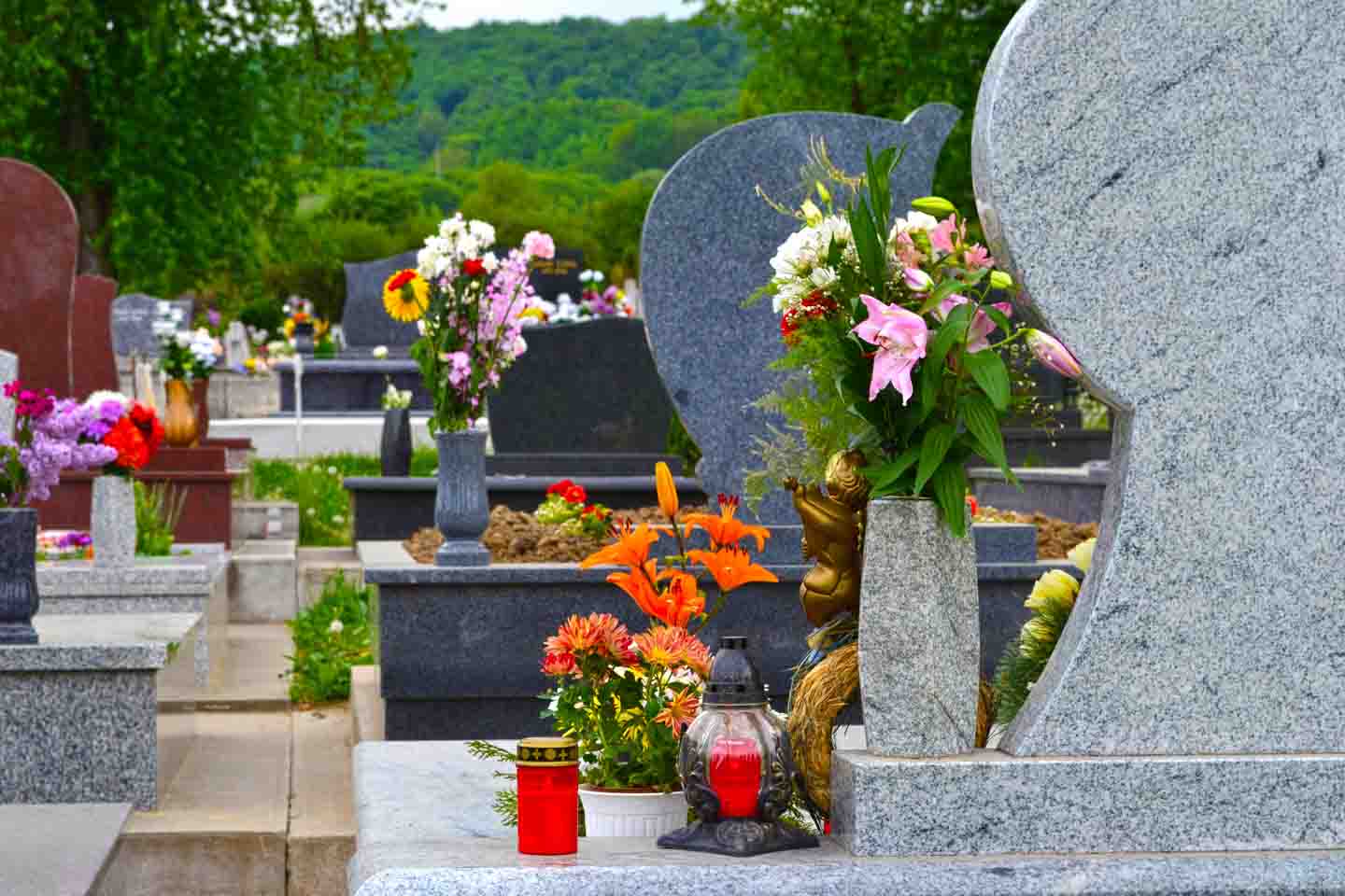 Friedhof mit blumengeschmückten Gräbern.