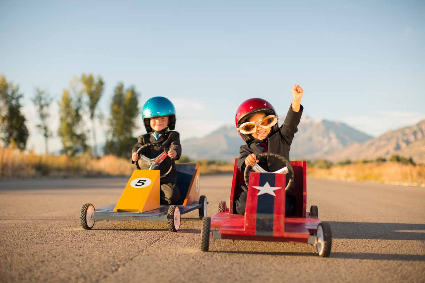 Zwei Kinder machen ein Seifenkistenrennen. 