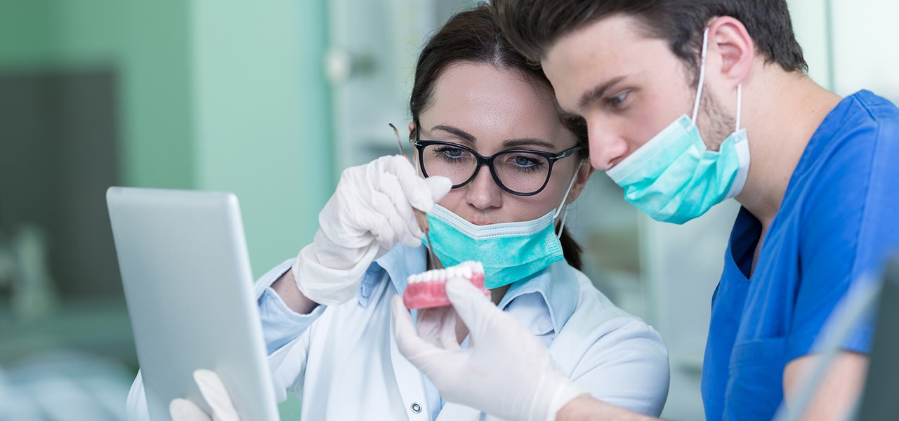 Zahntechniker – Ausbildung: Zahntechniker betrachten Zahnprothese