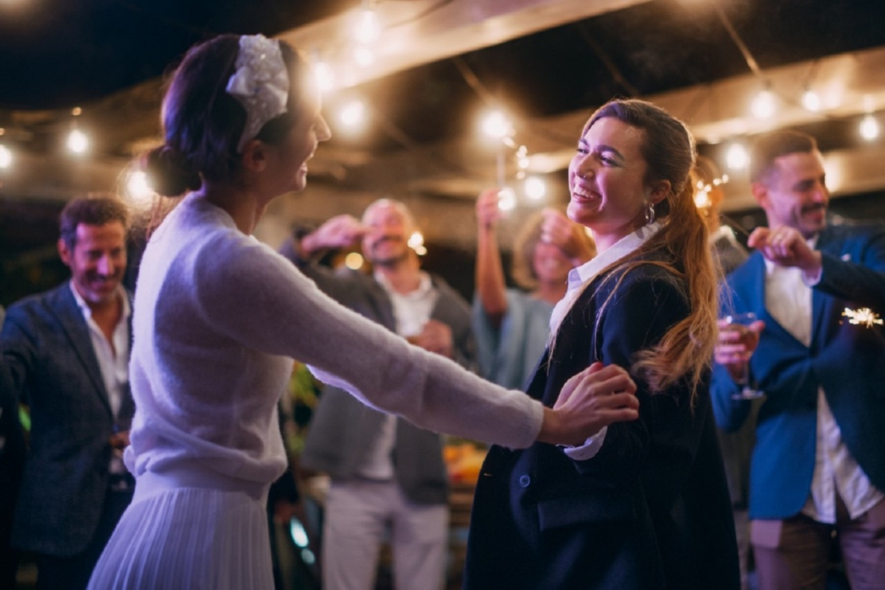 Eine Braut tanzt am Abend gemeinsam mit einer Freundin auf der Tanzfläche..