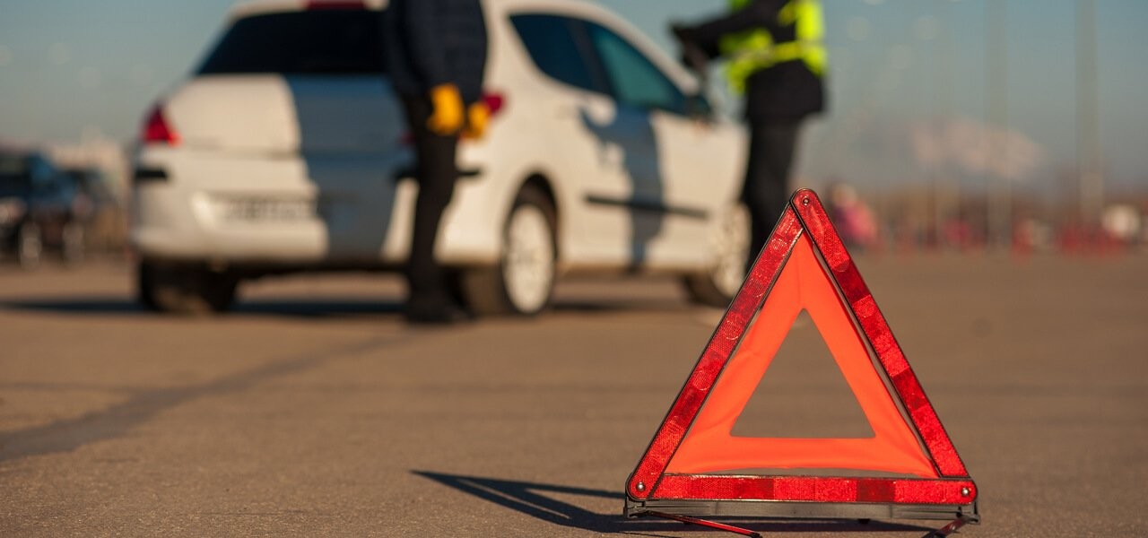 Aufgestelltes Warndreieck vor weißem Auto