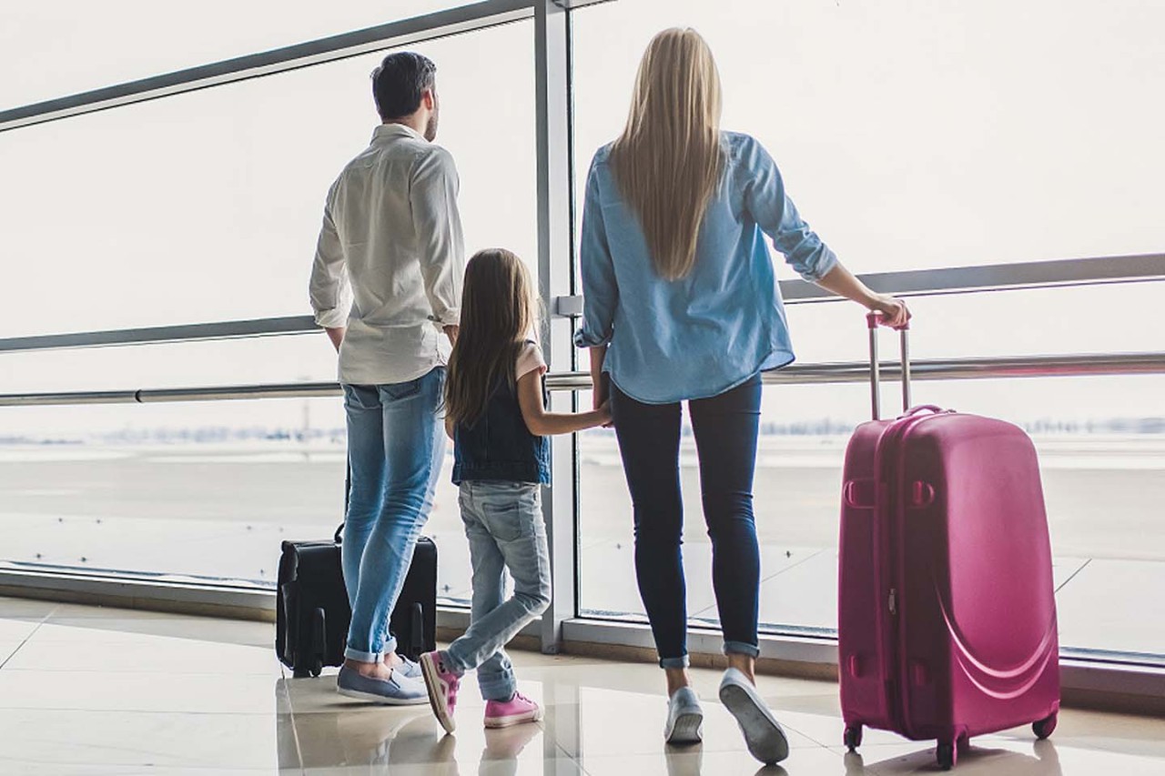 Eine junge Familie wartet am Flughafen auf ihren Ferienflieger.