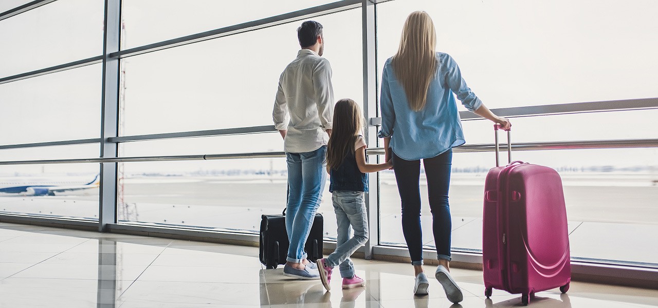 Eine junge Familie wartet am Flughafen auf ihren Ferienflieger.